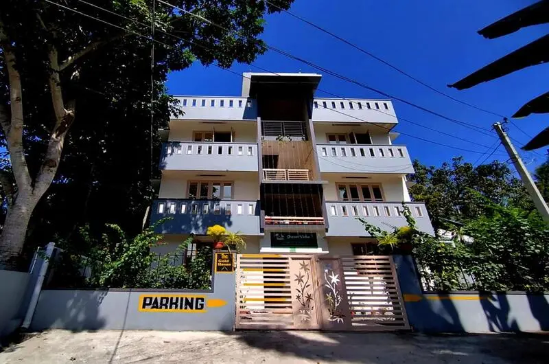 Multi-story modern building of Greenview Homestay Kovalam featuring private guest balconies and an on-site parking area.