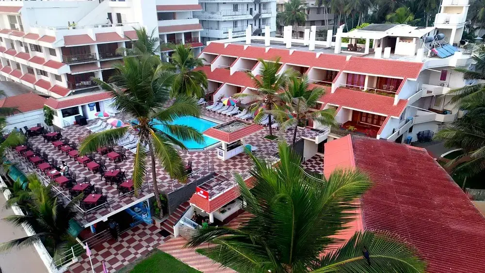 Terraced multi-story building of Hotel Sea Face Kovalam overlooking the central outdoor swimming pool and tropical courtyard.