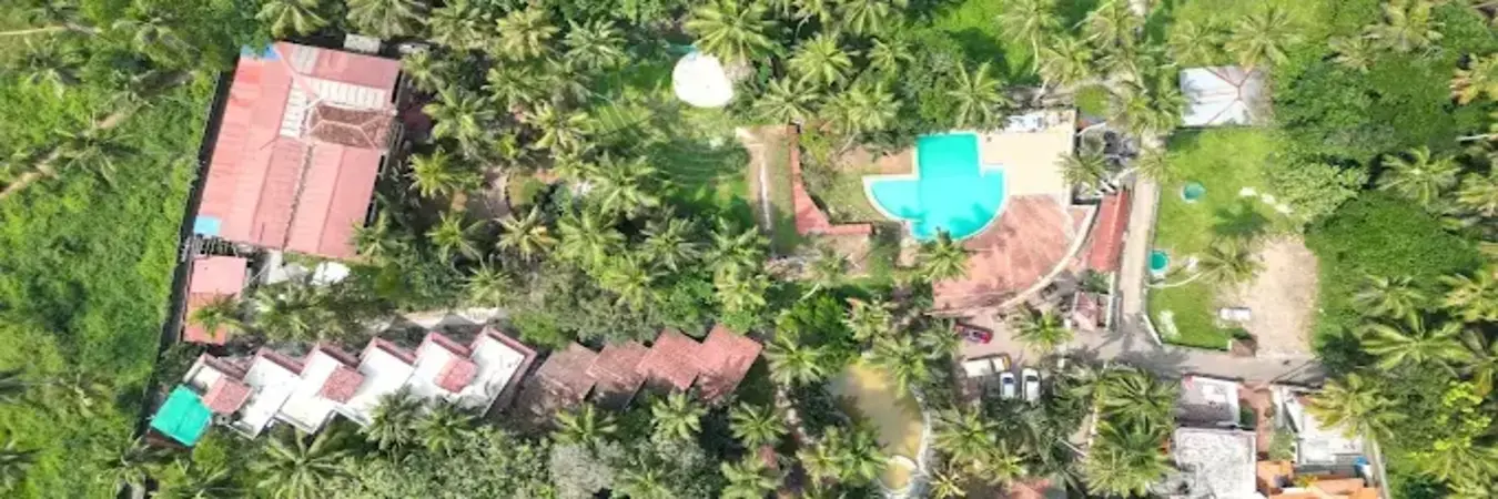 Aerial view of Country Club Kovalam Beach resort featuring premium accommodations and swimming pool surrounded by tropical greenery in Kerala.