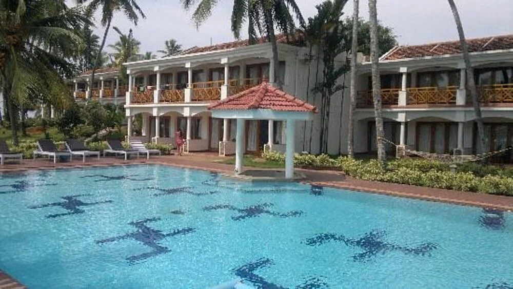 Outdoor swimming pool and poolside pavilion facing the terraced guest rooms at Samudra KTDC Kovalam