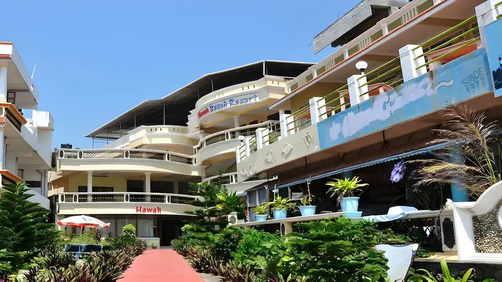 Wide angle daytime view of the curved multi-tiered balconies and outdoor seating area at Hawah Beach Resort Kovalam
