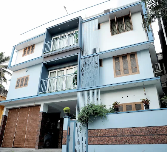 Close-up view of the modern balconies and brick-accented exterior walls at The Nest Homestay Kovalam