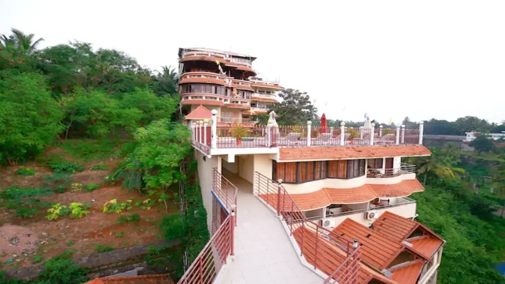 Multi-story brick facade architecture and elevated terrace structure of Oyo Hill and Sea View Resort Kovalam