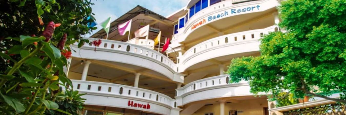 White multi story building facade with sea view balconies at Hawah Beach Resort Kovalam