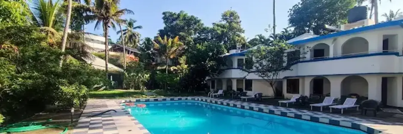 Outdoor swimming pool and guest room building at Treebo Trend Linchu Ayur Resort Kovalam