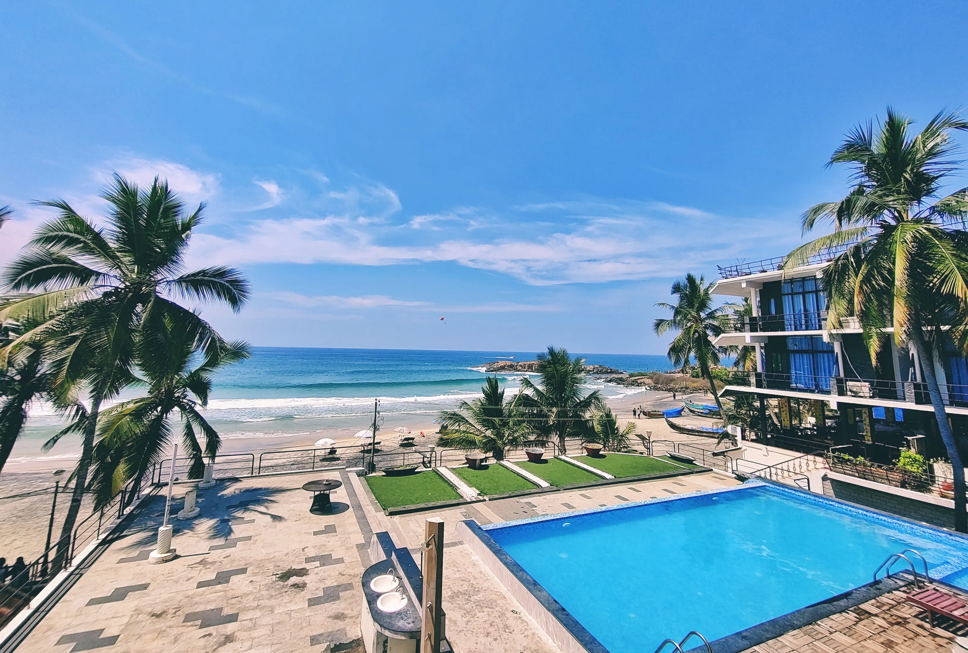Outdoor swimming pool and beachfront view at The Neelakanta Beach Resort on Lighthouse Beach Kovalam