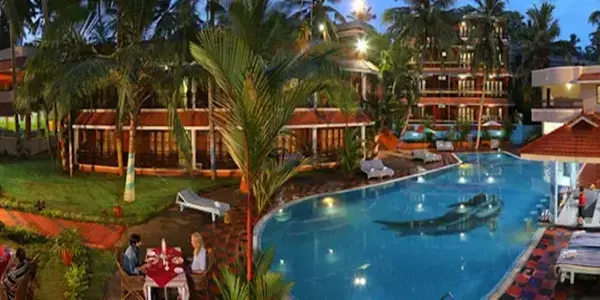 Luxury swimming pool and resort building at Jasmine Palace Kovalam.