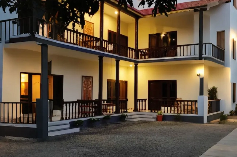 Outdoor swimming pool and courtyard at Jeevan Beach Resort Kovalam surrounded by palm trees