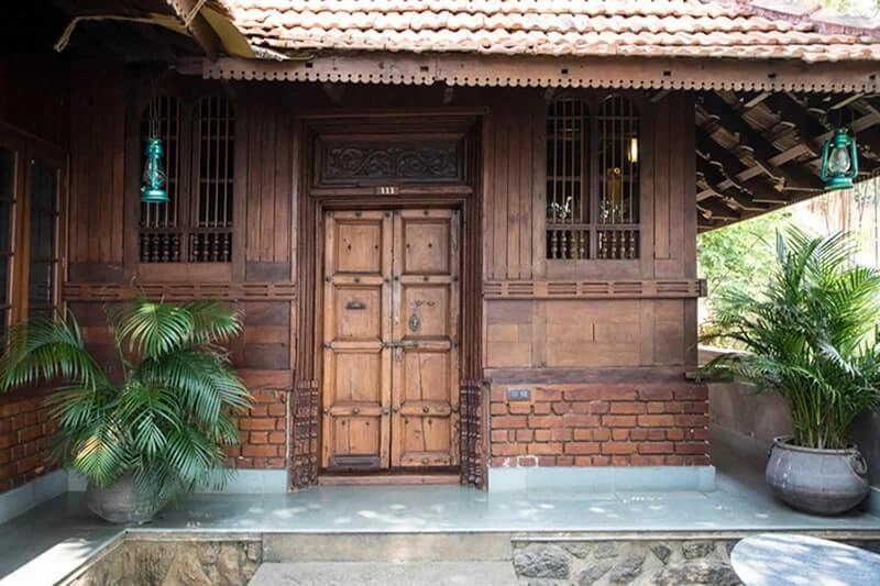 Intricately carved Kerala heritage wooden entrance door at Somatheeram Ayurvedic Health Resort Kovalam