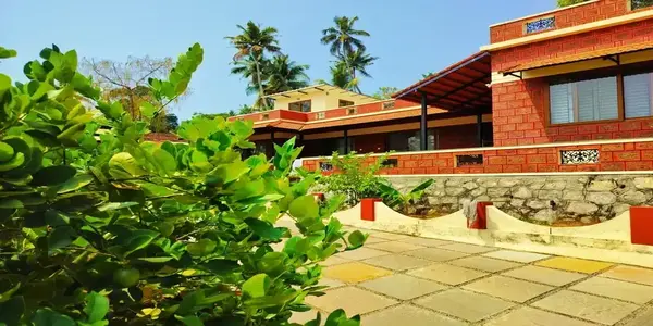 Lush green landscaping and modern brick building facade at The Ixora Homestay