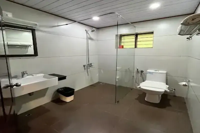 Clean modern attached bathroom interior featuring contemporary fittings at Abad Harmonia Kovalam.