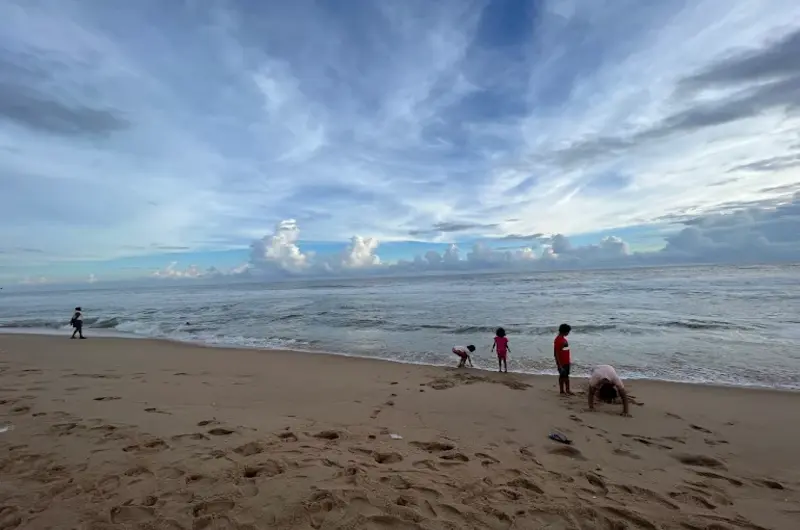Panoramic view of the sandy shoreline near Abad Harmonia Kovalam during the day.