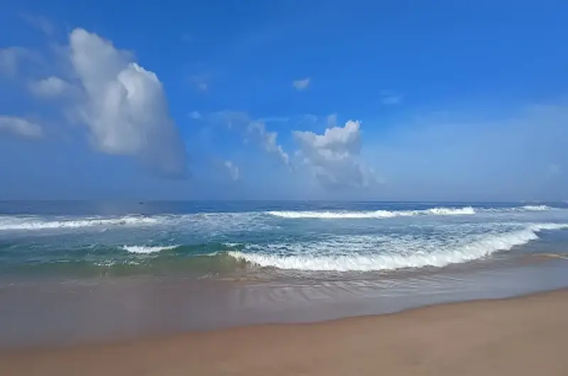 Scenic view of rolling ocean waves and golden sands at Chowara Beach near Kovalam.