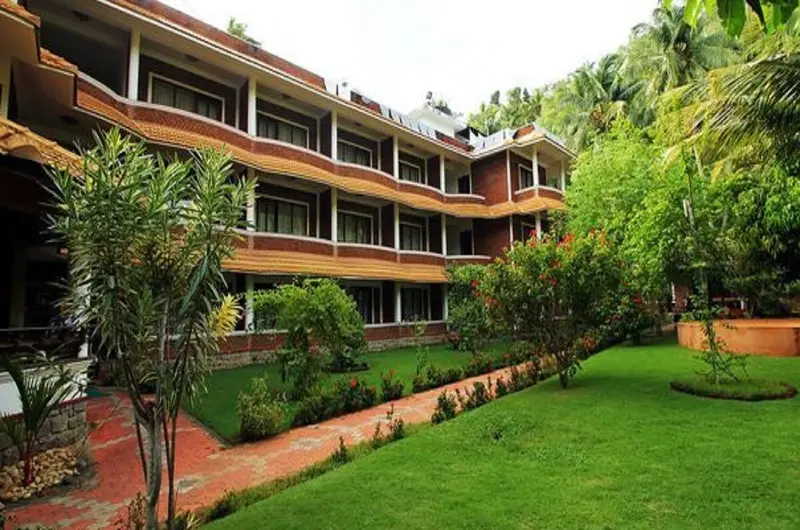 Traditional Kerala style cottage blocks and manicured green lawns at Abad Harmonia Kovalam.