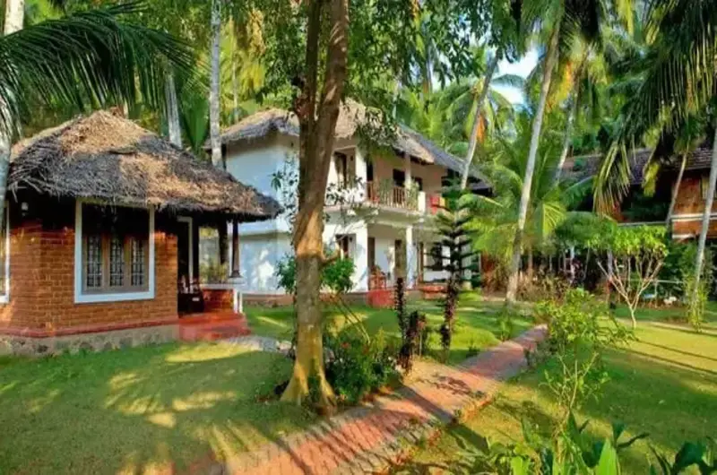 Premium garden cottages at Abad Harmonia resort in Kovalam surrounded by lush coconut palms.