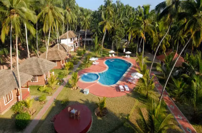 Luxury outdoor swimming pool courtyard with sunbeds at Abad Harmonia resort Kovalam.