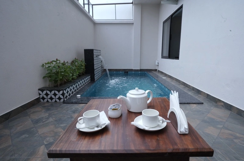 Private plunge pool area at Aadisaktthi Leisure Resort with outdoor tea seating setup.