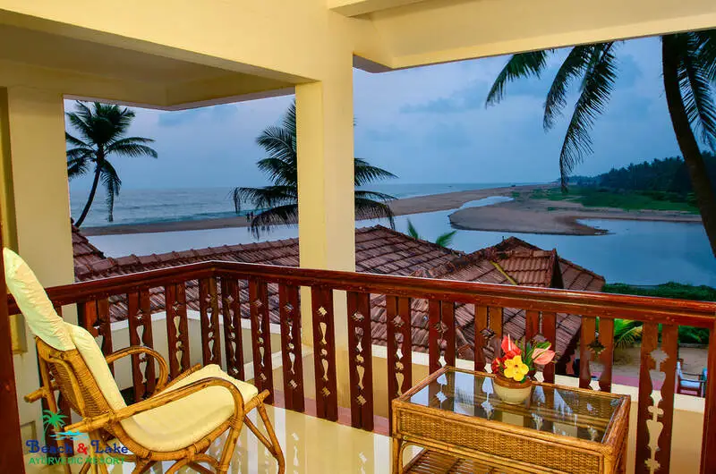 Scenic river and sea view from a private wooden balcony at Beach and Lake Ayurvedic Resort.