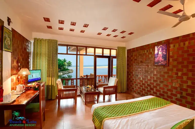 Elegant deluxe double bedroom interior featuring warm lighting at Beach and Lake Ayurvedic Resort.