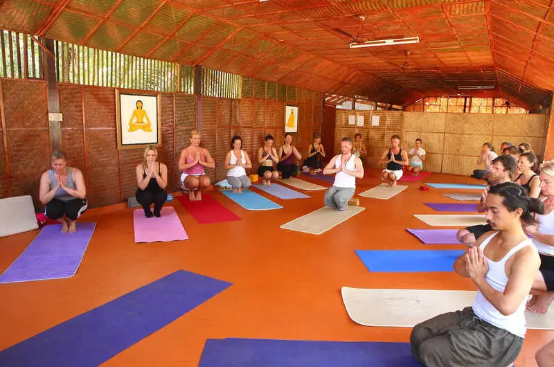 Group yoga session being conducted in the traditional wooden hall at Beach and Lake Ayurvedic Resort.