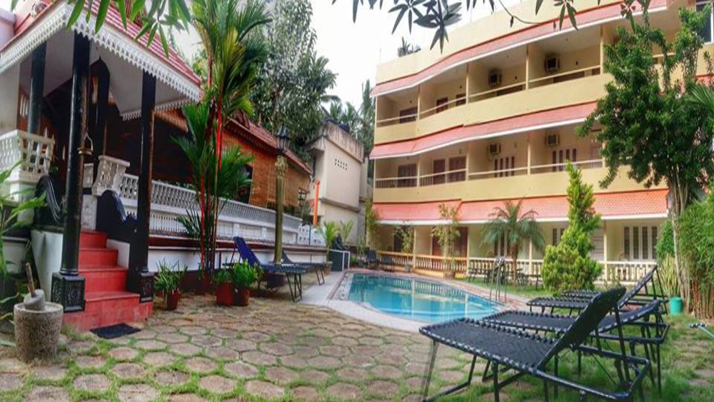 Exterior courtyard and white building facade of Golden Sands Beach Resort Kovalam during the day.
