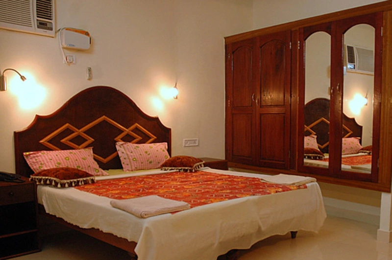 Spacious deluxe suite room interior with an elegant wooden wardrobe at Golden Sands Beach Resort Kovalam.