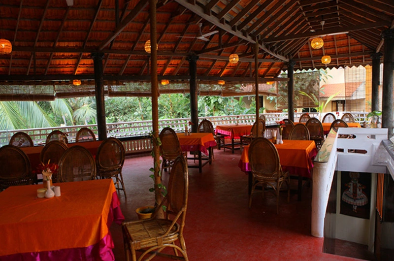 Covered outdoor dining area and multi-cuisine restaurant at Golden Sands Beach Resort Kovalam.