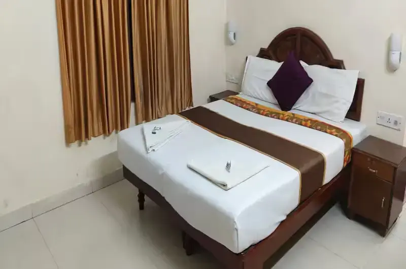 Standard AC hotel room interior with dark wood bed frame at Hawah Beach Resort