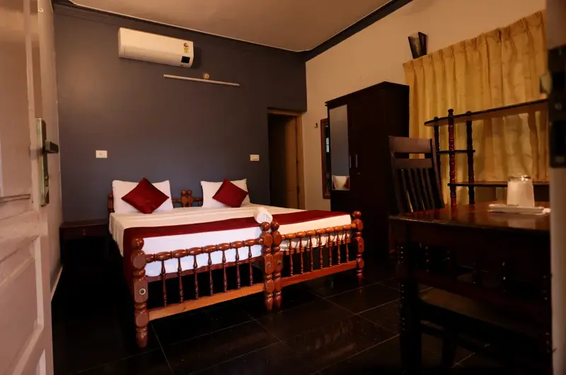 Premium twin bedroom accommodation featuring classic wooden beds at Ideal Ayurvedic Resort Kovalam.