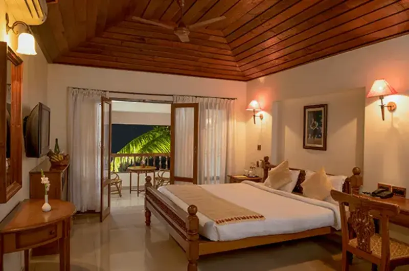 Air conditioned Executive Pavilion bedroom with traditional Kerala decor at Isola Di Cocco Resort