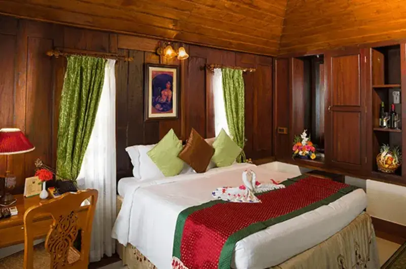 Heritage cottage bedroom with red accents and traditional Kerala architecture at Isola Di Cocco Kovalam