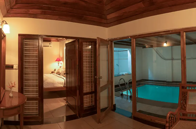 Traditional wood paneled Heritage Room interior at Isola Di Cocco Beach Resort Poovar