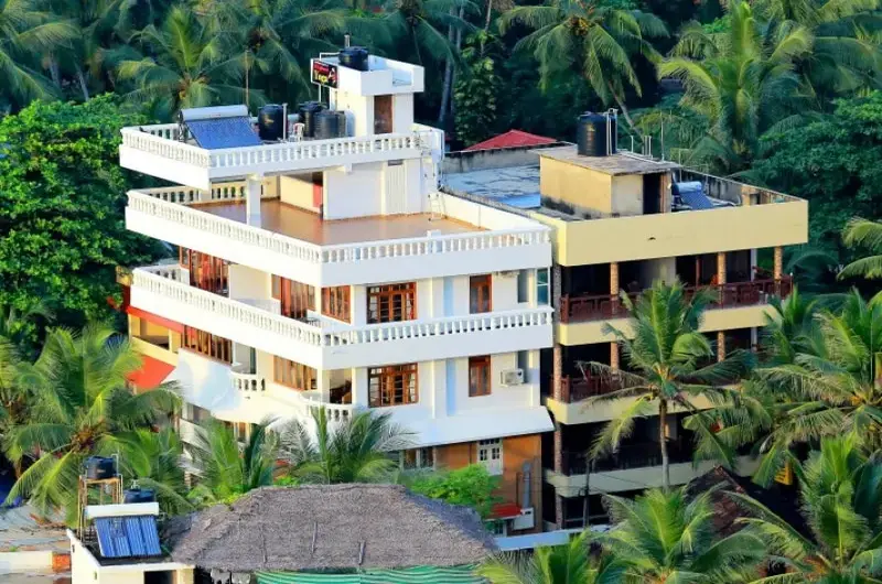 Exterior facade of Little Elephant Beach Resort Kovalam surrounded by lush coconut trees