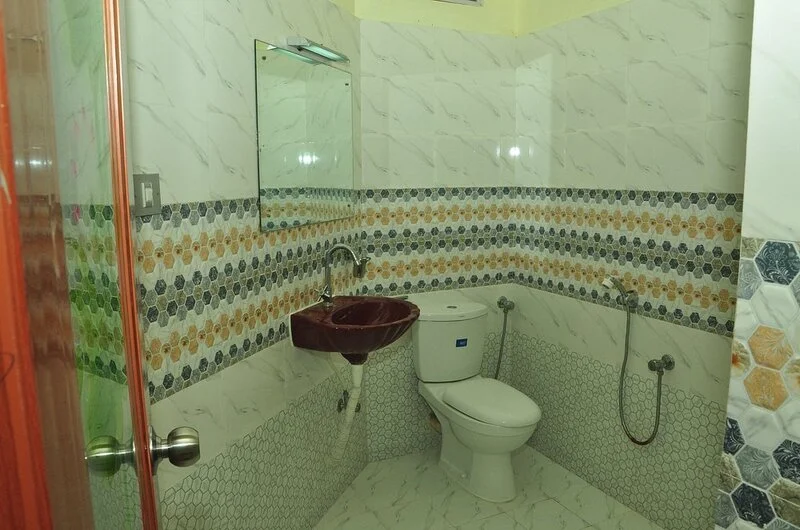 Clean contemporary bathroom layout with western toilet facilities at Pappukutty Beach Resort