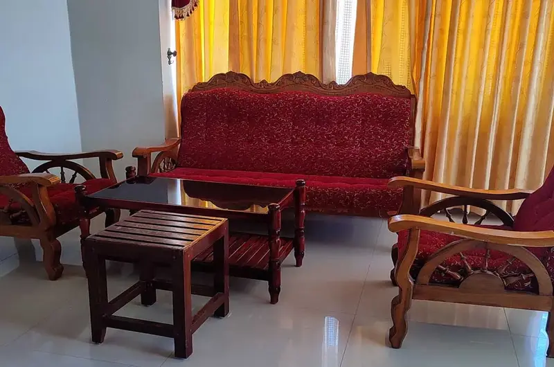 Guest lounge and seating area with traditional wooden furniture at Pappukutty Beach Resort