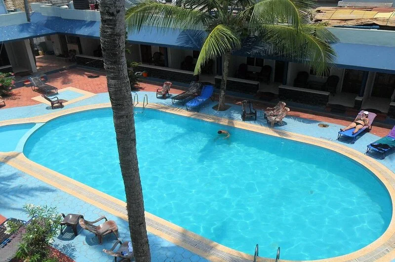 Outdoor swimming pool with sun loungers at Pappukutty Beach Resort Kovalam