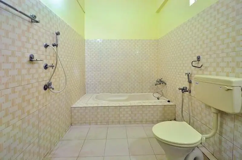 Ensuite bathroom featuring a modern bathtub setup at Pappukutty Beach Resort Kovalam