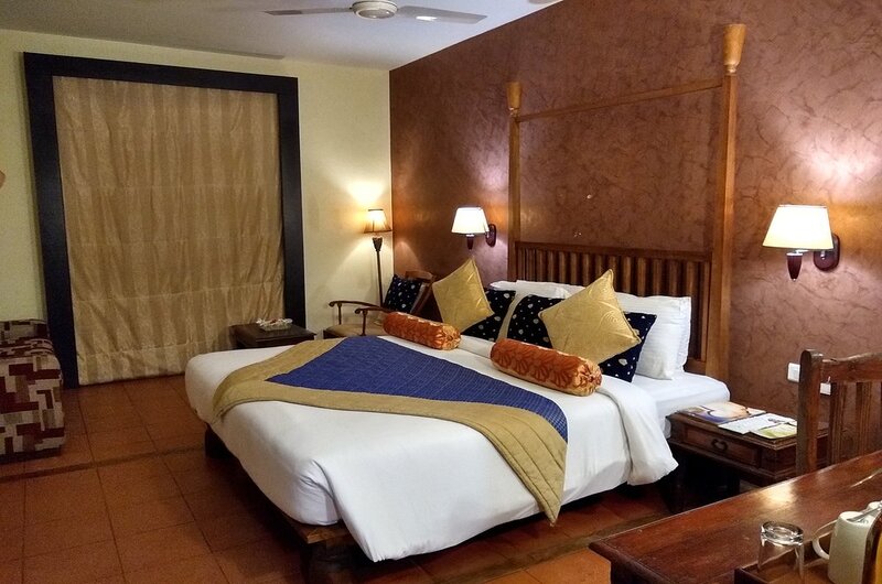 Premium land cottage bedroom with elegant wood furnishings at Poovar Island Resort