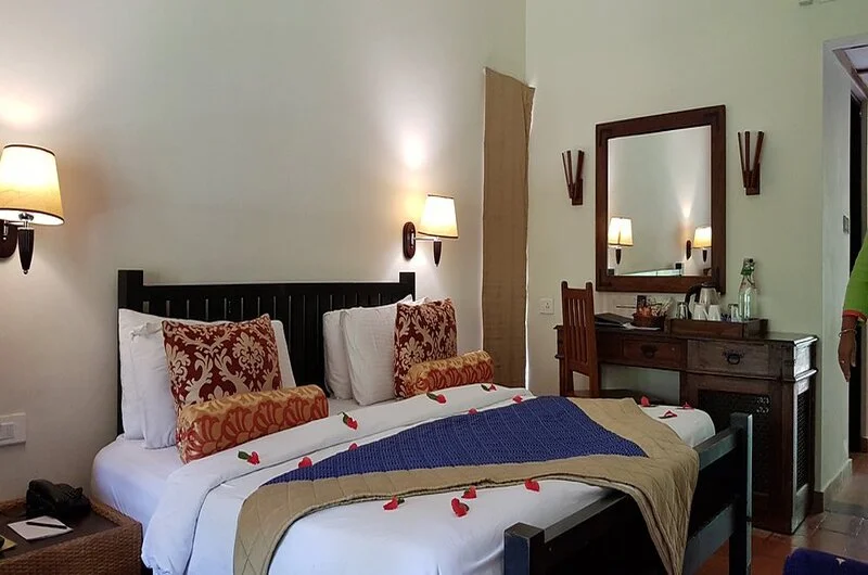 Spacious deluxe room interior featuring contemporary decor and a private veranda at Poovar Island Resort Kerala