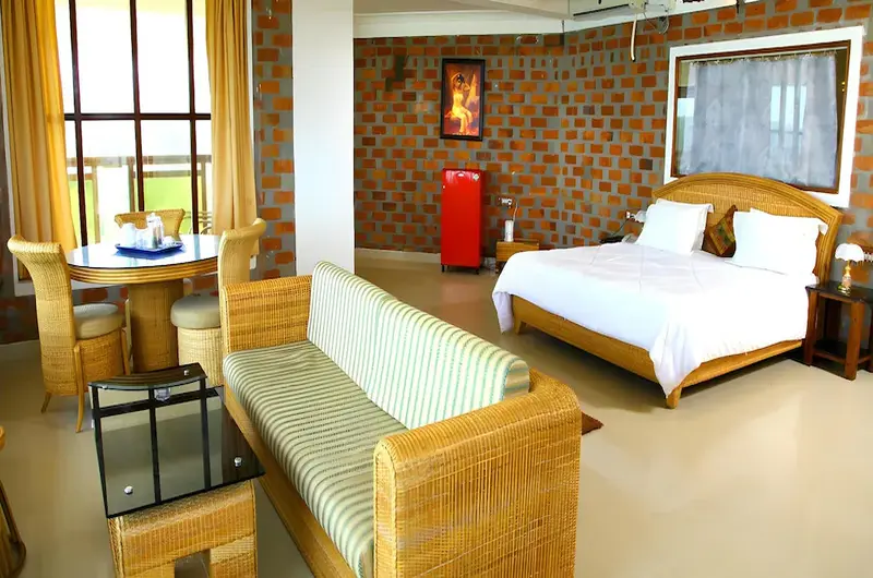 Luxury resort suite bedroom with attached sitting area at Sagara Beach Resort Kovalam