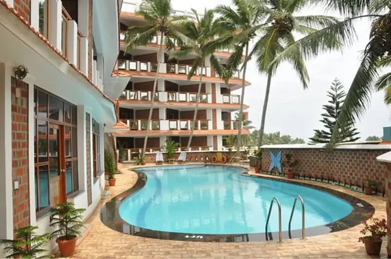 Outdoor swimming pool with sun loungers at Sagara Beach Resort Kovalam