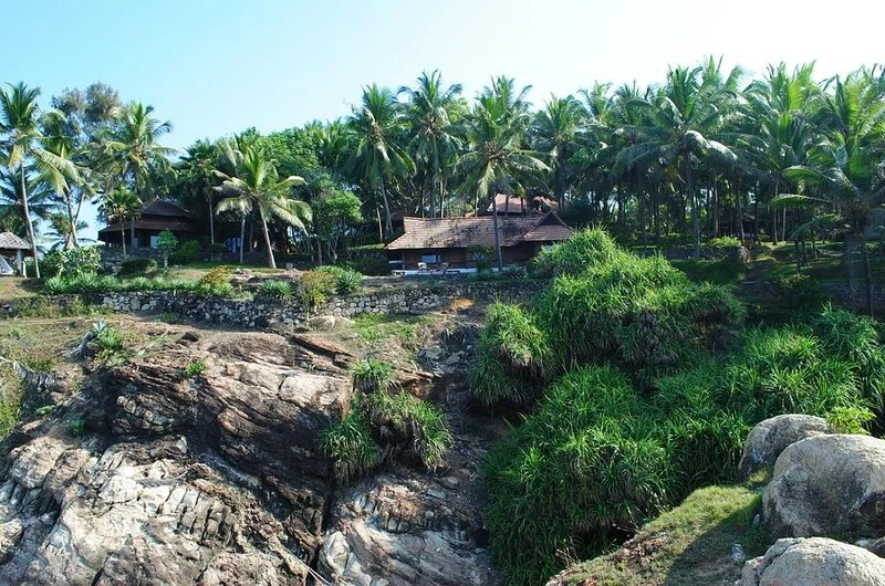 Luxury cliffside property surrounded by lush tropical greenery at Niraamaya Retreats Surya Samudra Kovalam