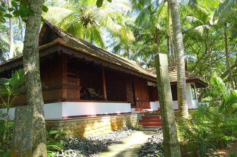 Traditional Kerala heritage wooden cottage facade at Niraamaya Retreats Surya Samudra