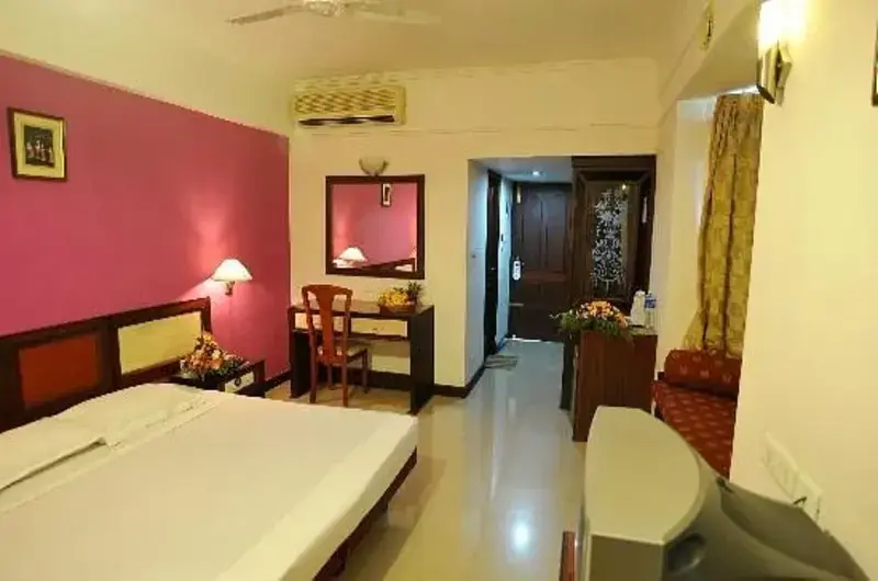 Premium double bedroom accommodation with vibrant interiors and private seating at Swagath Holiday Resort Kovalam