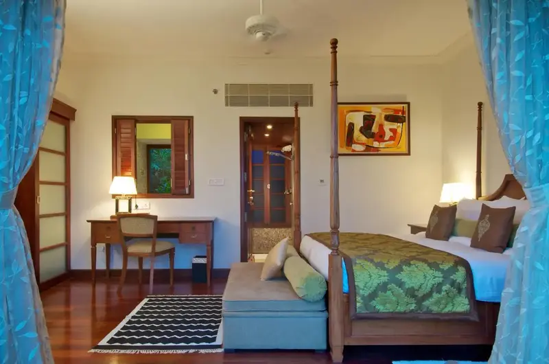 Classic luxury suite interior featuring a four poster bed at Taj Green Cove Resort Kerala