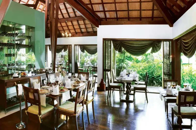 Elegant fine dining restaurant with traditional wooden roof at Taj Green Cove Resort Kovalam