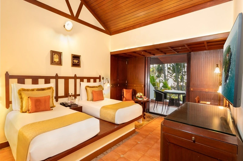 Luxury club twin bedroom featuring a traditional high wooden ceiling at The Leela Kovalam