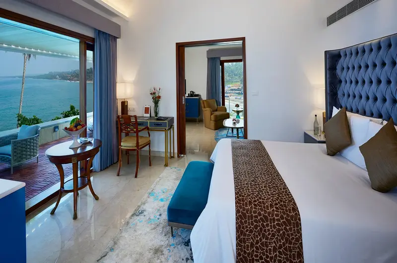 Luxury guest bedroom with private ocean view balcony at The Leela Kovalam