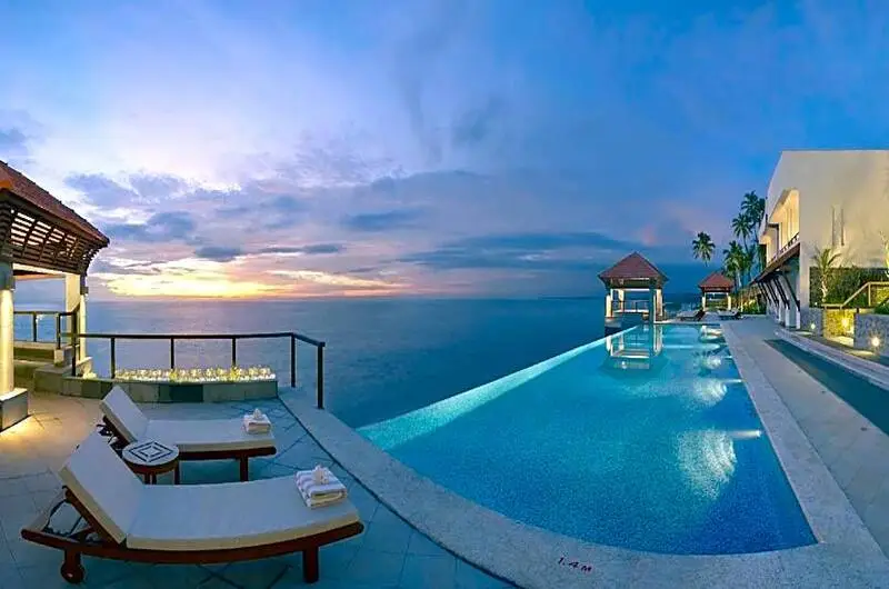 Luxury infinity swimming pool overlooking the Arabian Sea at evening in The Leela Kovalam