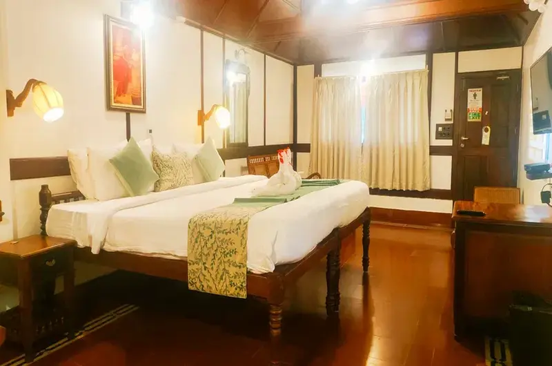 Heritage twin bedroom featuring a traditional Kerala wooden ceiling at The Travancore Heritage Beach Resort